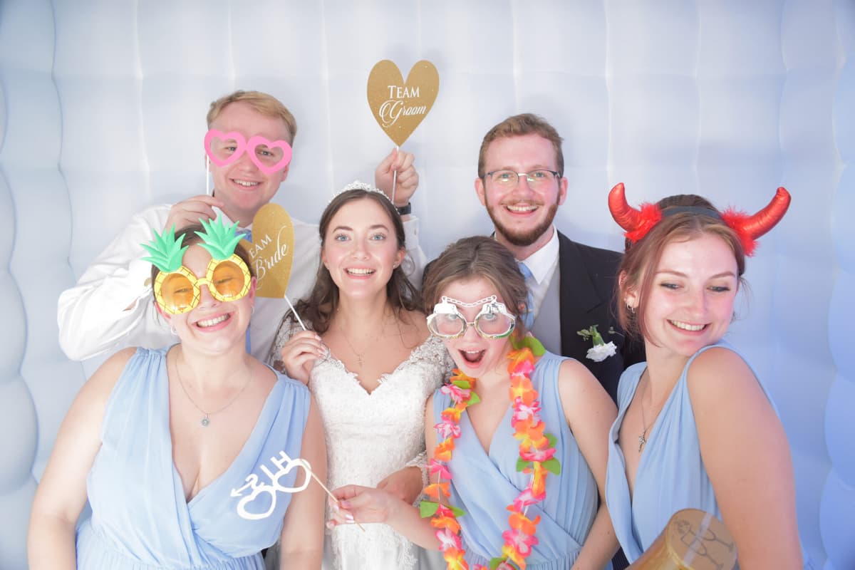 Bridal party posing with fun props in the photo booth