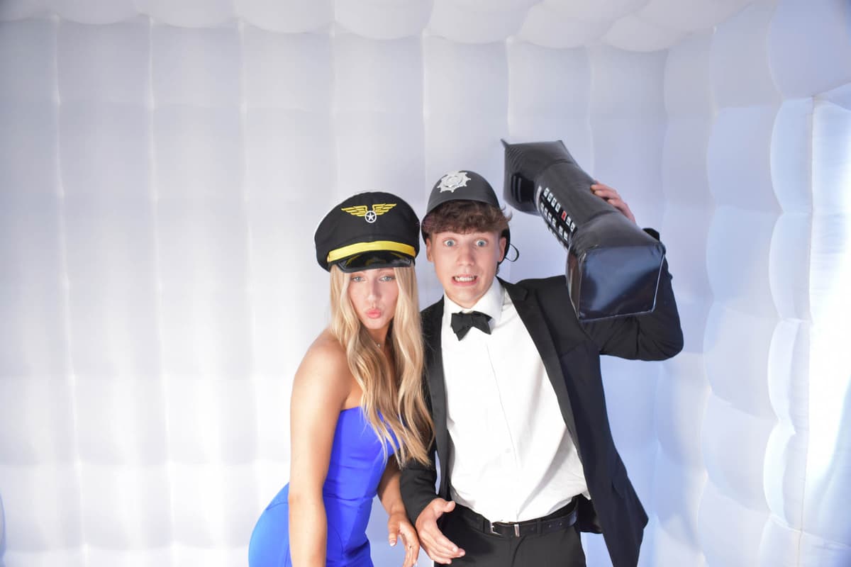 Prom guests posing with fun props in the photo booth