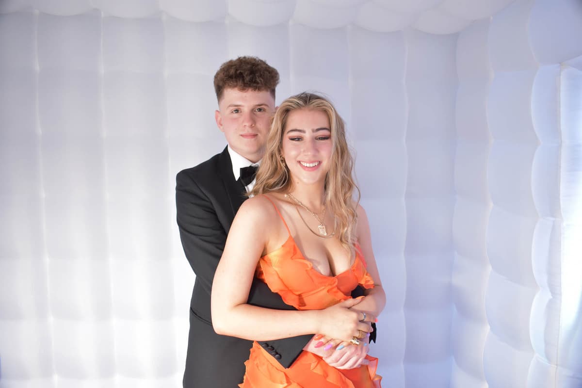 Prom couple posing together in the photo booth
